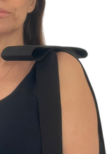 Load image into Gallery viewer, Close-up of a model wearing a black sleeveless top with a wide, structured bow brooch pinned at shoulder set against a plain white background.